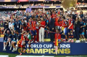 FIFA World Cup 2026 - Final - Spain v Argentina - عروبة الاخباري | Oroba News Soccer players and staff celebrate on a podium with medals and a trophy during the World Cup 2026 champions event.