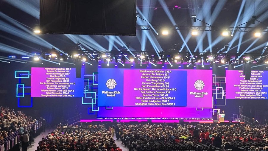 740198223_122367376886016148_4885515430978329038_n - عروبة الاخباري | Oroba News Large auditorium with a stage, purple screens reading Platinum Club Award, and a speaker at the podium before a seated audience.
