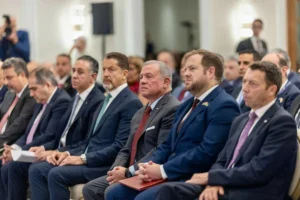 757412 - عروبة الاخباري | Oroba News Group of men in suits seated in a formal conference room during a professional event.