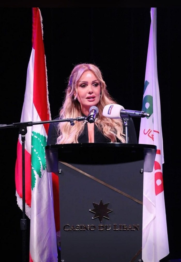 WhatsApp Image 2026-07-05 at 104000 AM1 - عروبة الاخباري | Oroba News Blonde woman in a black outfit speaks at a podium labeled Casino du Liban, with the Lebanese flag and another banner behind her.