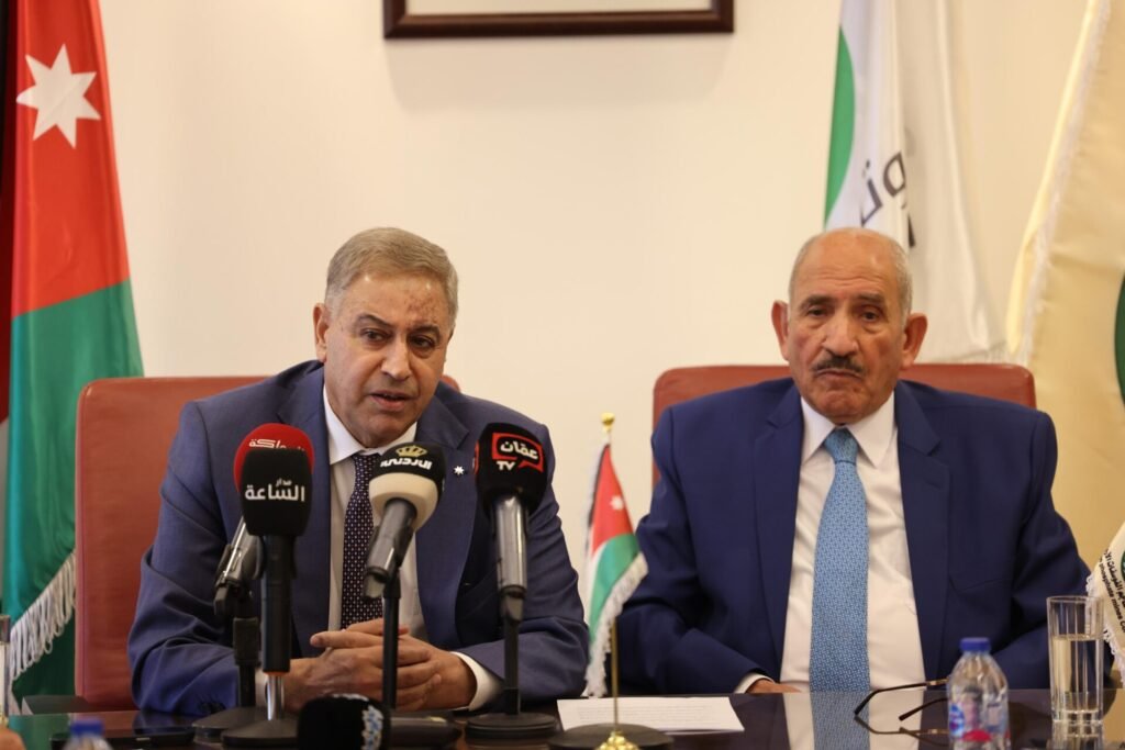 WhatsApp Image 2026-07-19 at 31545 PM1 - عروبة الاخباري | Oroba News Two men in suits seated at a press conference with multiple microphones in front and Jordan flag behind them.