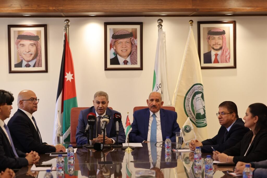 WhatsApp Image 2026-07-19 at 31545 PM2 - عروبة الاخباري | Oroba News Officials in suits sit around a glossy conference table; microphones and water bottles in front, flags behind, a press briefing scene.