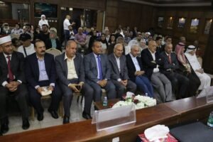WhatsApp Image 2026-07-22 at 125631 AM - عروبة الاخباري | Oroba News Group of men in suits seated in a formal conference room, with a floral centerpiece on the table in front.