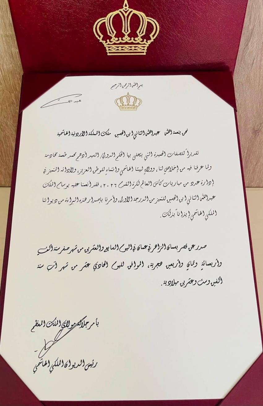 Formal Arabic document inside a red folder with a gold crown emblem at the top center, bordered by gold corners on the page edge, suggesting an official letter.