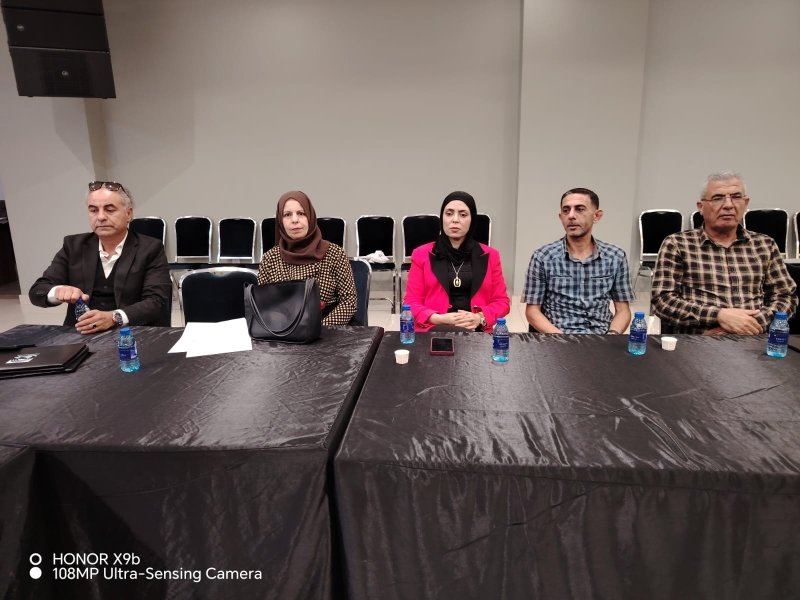 6a73a845219ca - عروبة الاخباري | Oroba News Five adults seated along a long black-draped conference table in a meeting room, with water bottles and cups in front of them (panel setting).