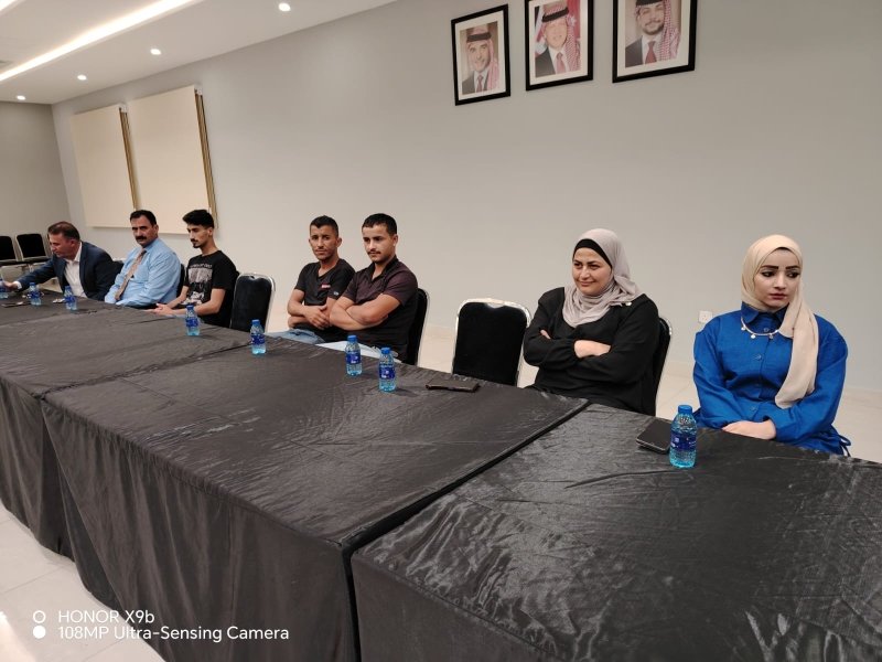 6a73a8454b1bb - عروبة الاخباري | Oroba News Group of people seated along a long conference table in a meeting room, with water bottles and framed portraits on the wall behind.