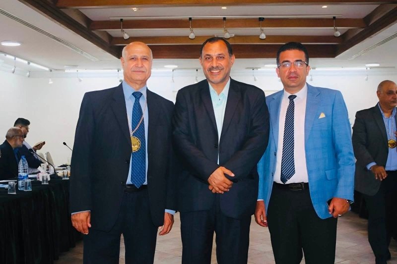 6a74778c014fd - عروبة الاخباري | Oroba News Three men in suits posing for a group photo at an indoor formal event, smiling at the camera.