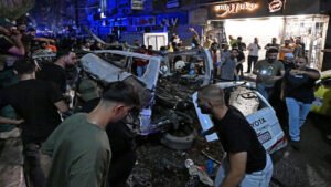 6a74d7363d147 - عروبة الاخباري | Oroba News Crowd of bystanders gathers around a severely damaged white Toyota SUV after a nighttime crash on a crowded street.