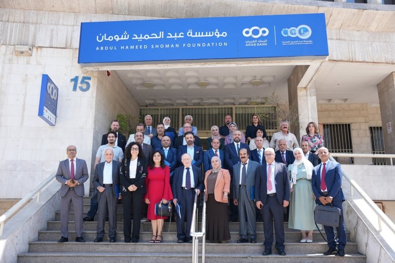 6a772a355cf47 - عروبة الاخباري | Oroba News Group of men and women in formal attire posing on the stairs at the Abdul Hameed Shoman Foundation entrance.
