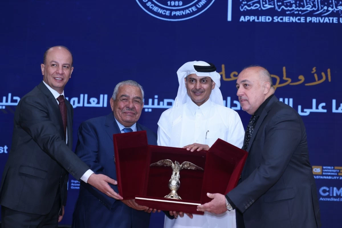 760751 - عروبة الاخباري | Oroba News Group of four men in formal attire presenting a silver eagle trophy in a red case at an awards ceremony against a blue backdrop with logos and Arabic text.