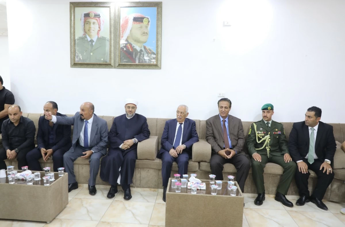 764105 - عروبة الاخباري | Oroba News Group of men in suits and a military officer seated on a beige sofa in a meeting room, one man gesturing while others listen.