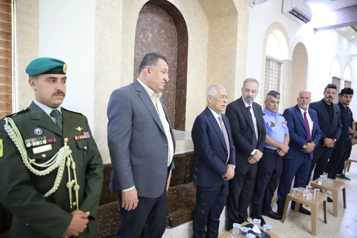 Group of men in suits and a green-uniformed military officer stand in a row during a formal ceremony inside a marble-floored hall.