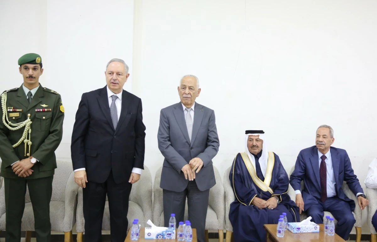 765040 - عروبة الاخباري | Oroba News Group of men in formal attire and a military officer stand beside a row of chairs in a meeting room.
