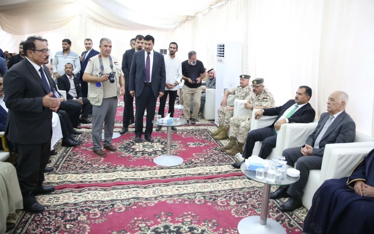 765045 - عروبة الاخباري | Oroba News Formal meeting in a white tent: men in suits and military uniforms stand and sit around a red patterned carpet.