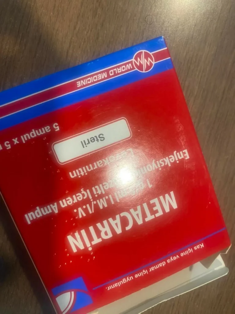 Red packaging box with a blue top border and a white label reading Steril, on a wooden surface.