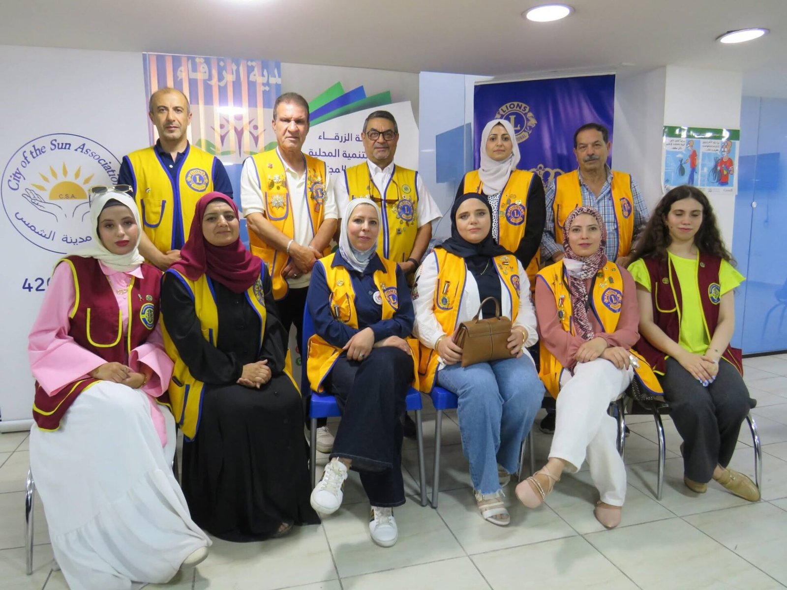 773034412_122374744178016148_6346615775482993803_n - عروبة الاخباري | Oroba News Group of Lions Club volunteers in yellow vests posing indoors for a photo.