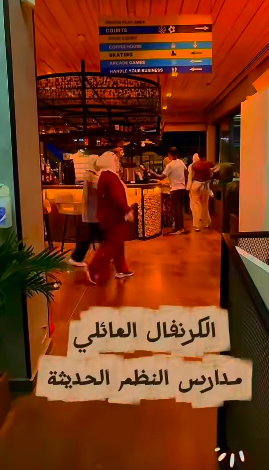 WhatsApp Image 2026-08-01 at 33333 PM 4 Interior of a warmly lit cafe or food court with people at a counter; torn white sheets with Arabic text cover the doorway, blocking entry.