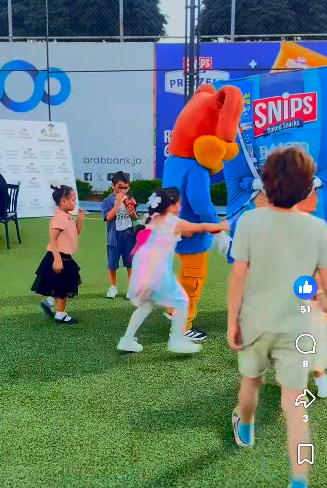 WhatsApp Image 2026-08-01 at 33333 PM 5 Children playing on a turf field with a large orange-and-blue mascot in the background at an outdoor event homescreen area.