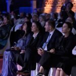 WhatsApp Image 2026-08-04 at 41236 PM 5 - عروبة الاخباري | Oroba News Audience seated at a formal event, front row watching intently in evening lighting.