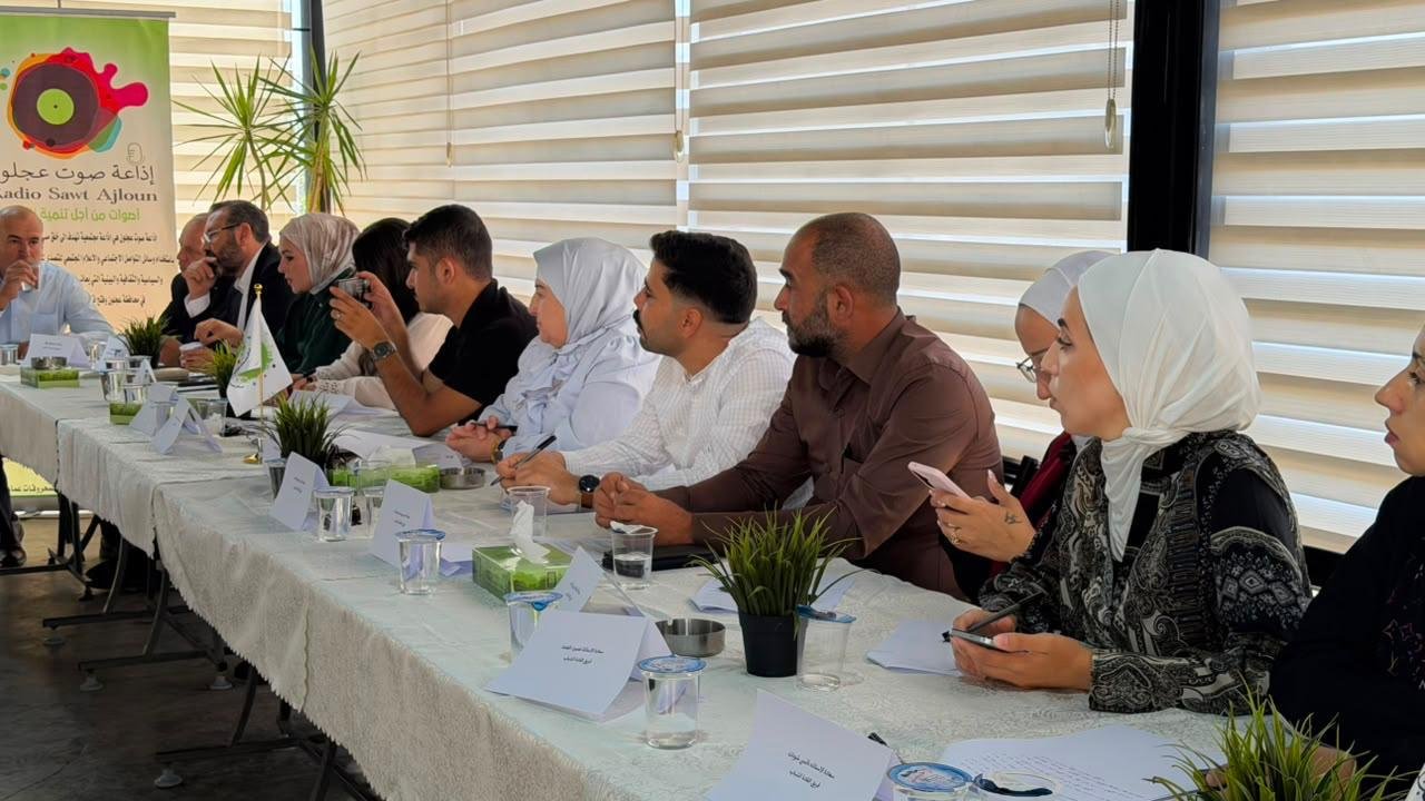 Group of professionals seated along a long conference table, discussing during a meeting.