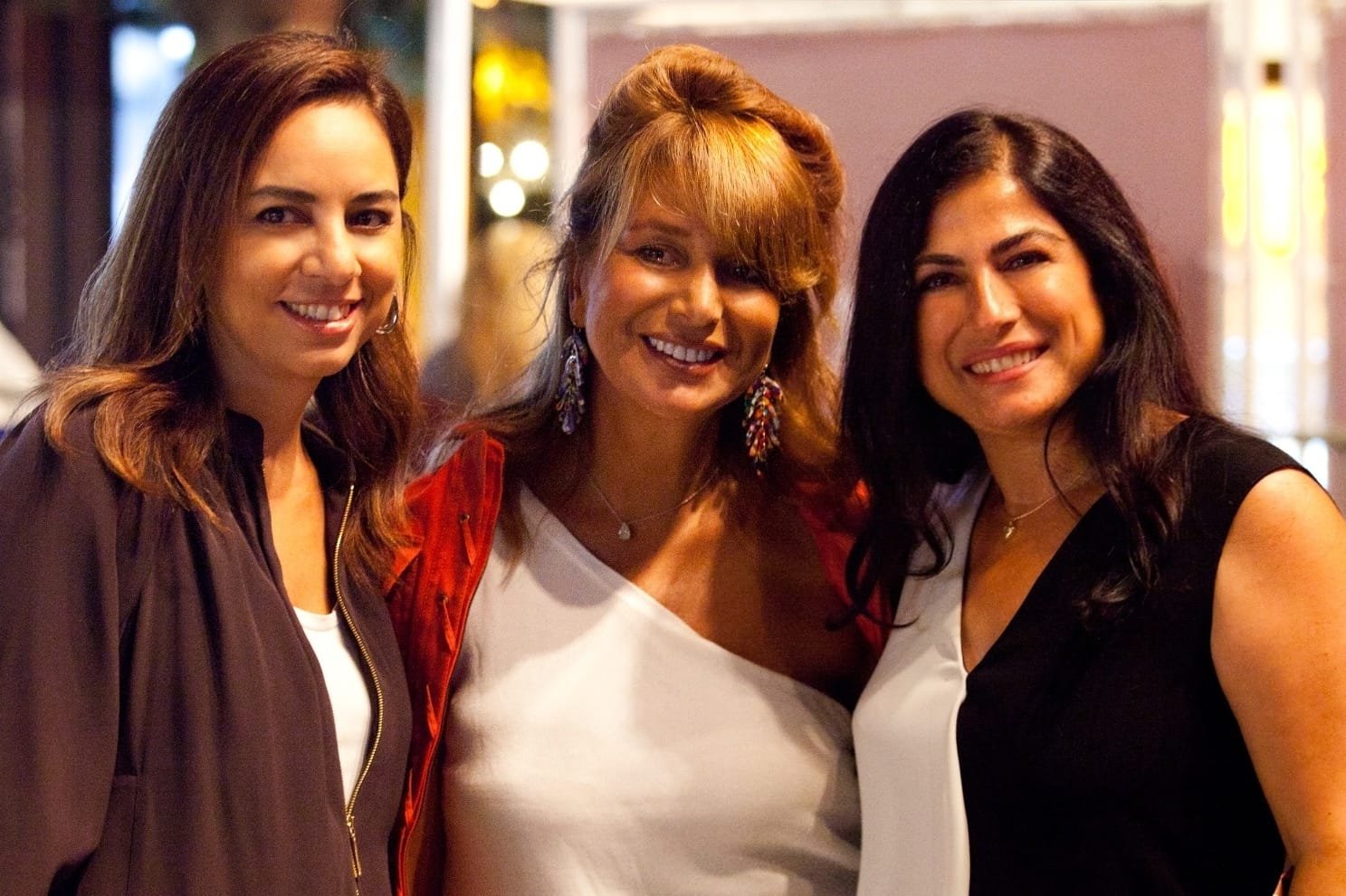 WhatsApp Image 2026-08-10 at 45552 PM 1 - عروبة الاخباري | Oroba News Three friends posing and smiling for a photo indoors at a social event.