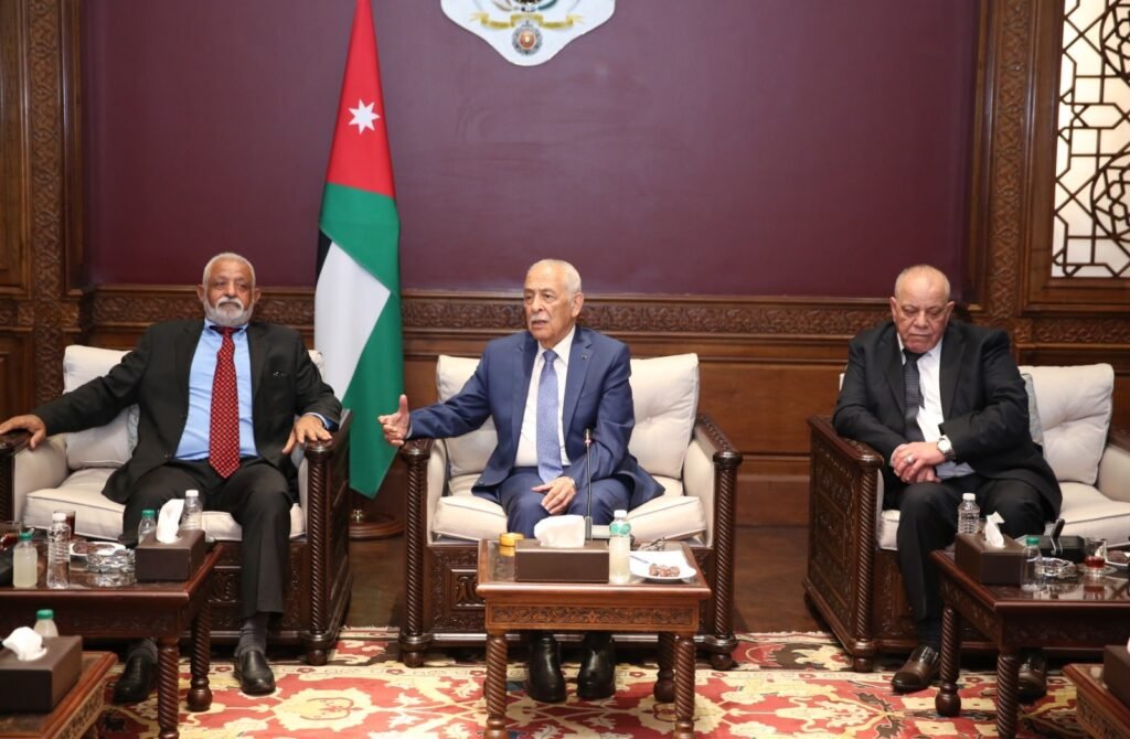 WhatsApp Image 2026-08-19 at 25101 PM - عروبة الاخباري | Oroba News Three men in suits sit on ornate chairs in a wood-paneled room, with a Jordan flag behind them, during a formal meeting.