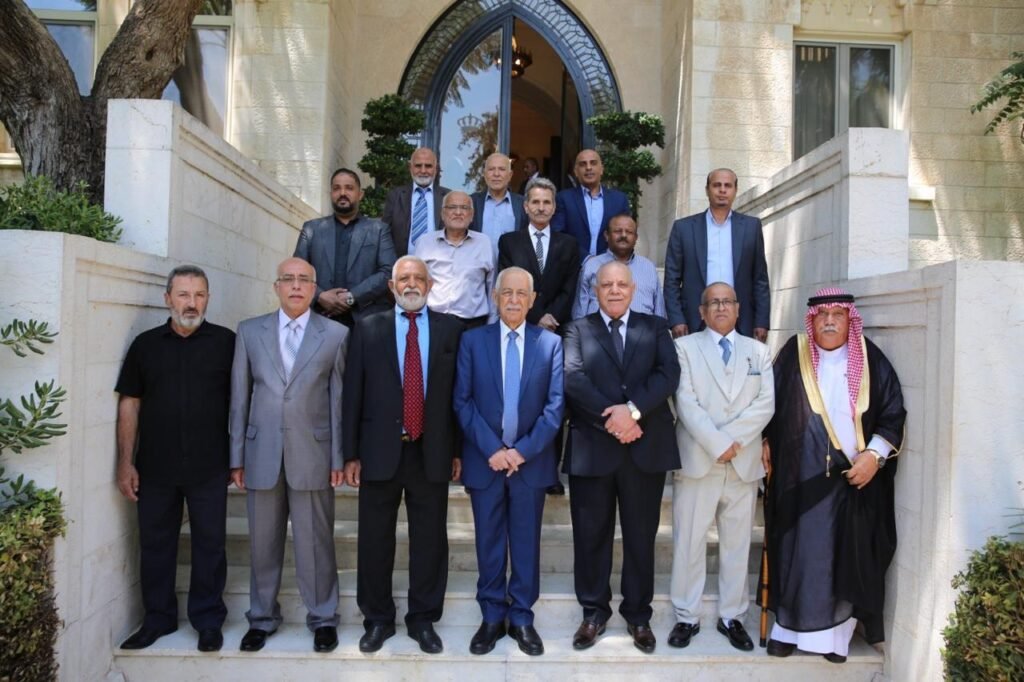 WhatsApp Image 2026-08-19 at 25219 PM - عروبة الاخباري | Oroba News Group of men in suits posing on stone steps in front of a building with an arched doorway. The rightmost man wears traditional Saudi attire.
