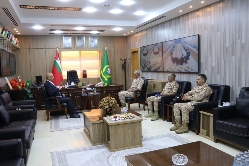WhatsApp Image 2026-08-19 at 52103 PM4 - عروبة الاخباري | Oroba News Formal office meeting: a civilian official sits at a large wooden desk while three uniformed soldiers sit in chairs to the right, with flags and portraits behind.