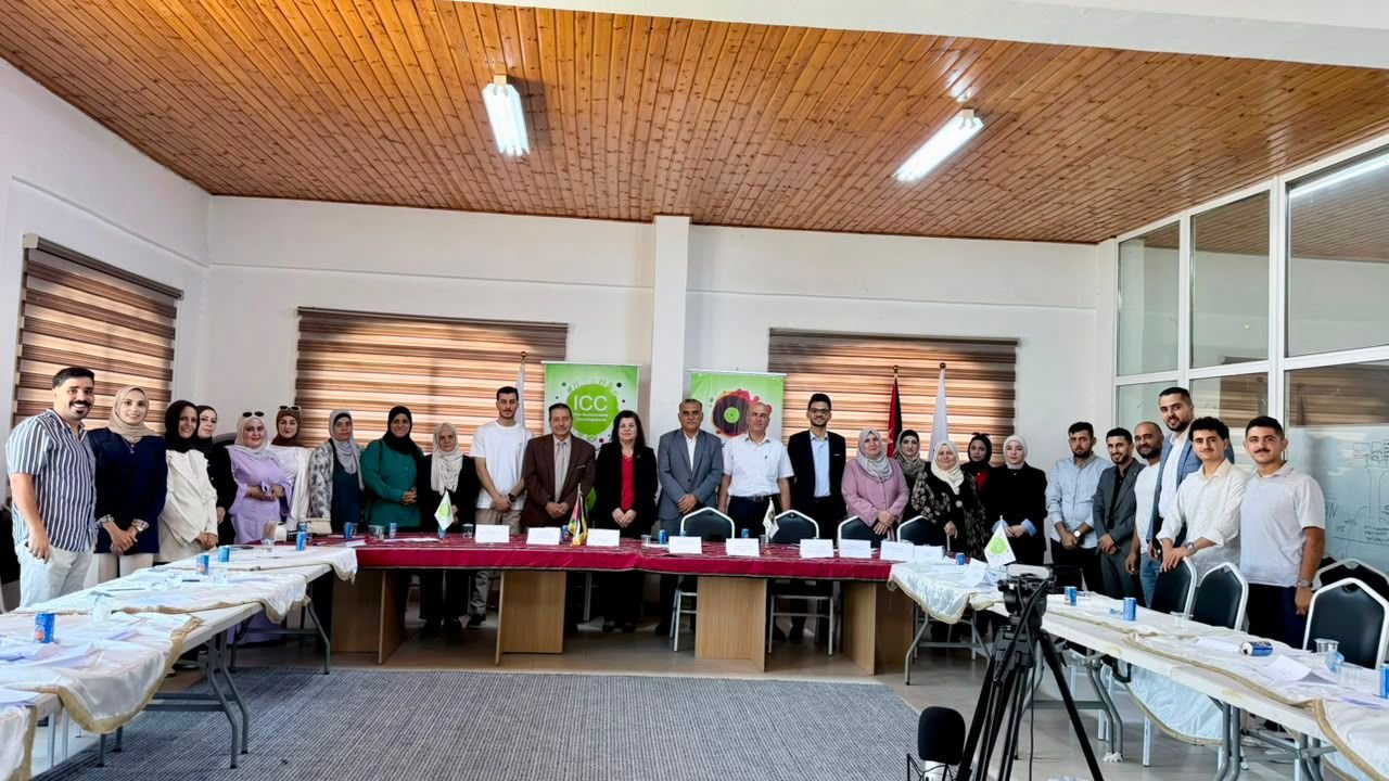Diverse group of professionals posing for a photo in a conference room with a long table and banners in the back.