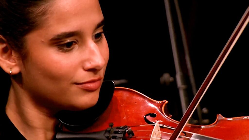 WhatsApp Image 2026-08-29 at 123204 PM 3 - عروبة الاخباري | Oroba News Close-up of a violinist's face as she plays, bow drawn across the strings.