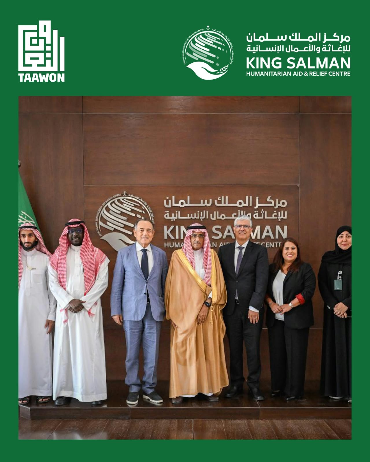 WhatsApp Image 2026-08-30 at 102802 AM - عروبة الاخباري | Oroba News Group of men and women in formal and traditional dress posing for a photo in front of a wall with the King Salman Humanitarian Aid & Relief Centre logo and Taawon branding on green borders.