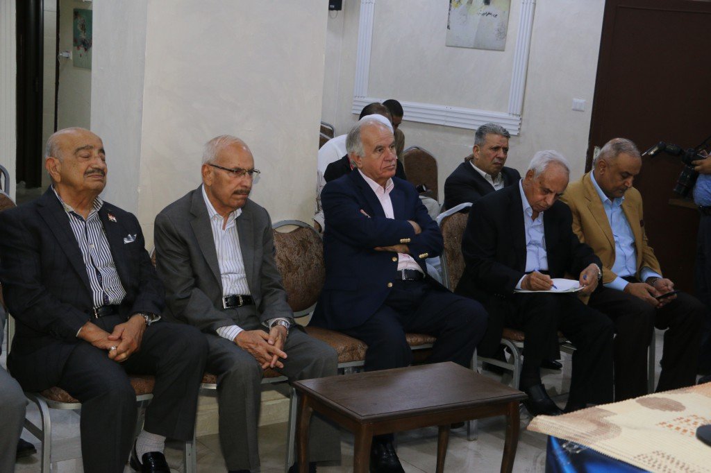 WhatsApp Image 2026-08-31 at 122509 AM - عروبة الاخباري | Oroba News Group of men in suits seated in a row at a formal meeting, some watching the speaker and one taking notes.