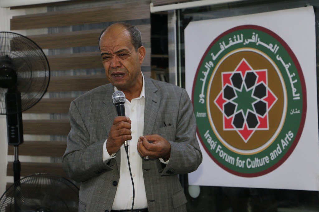 WhatsApp Image 2026-08-31 at 122515 AM - عروبة الاخباري | Oroba News Man in a gray suit speaks into a microphone at a cultural arts event, with a circular forum banner in the background read 'Forum for Culture and Arts'