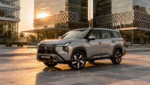 hf_20260823_142836_2bae6ac2-04d5-4d52-949d-885e6c7b4ad3 - عروبة الاخباري | Oroba News Silver Destinator SUV in a modern city plaza at sunset, glass skyscrapers in the background.