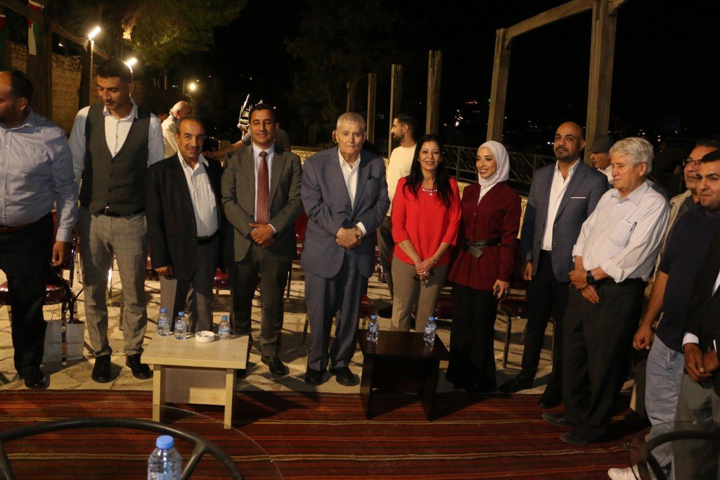 WhatsApp Image 2026-09-07 at 122859 AM - عروبة الاخباري | Oroba News Group of people in formal clothes standing in a line at a nighttime outdoor event, facing the camera.